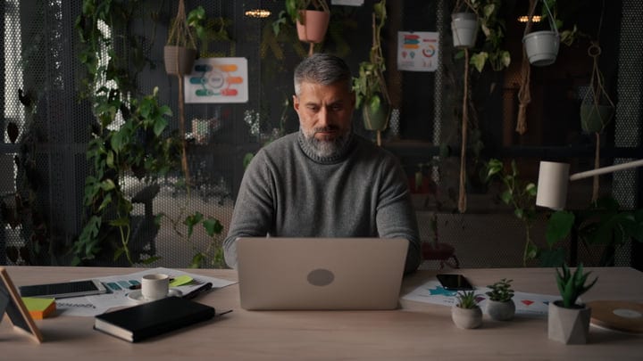 Focused Businessman in Modern Green Office Setting