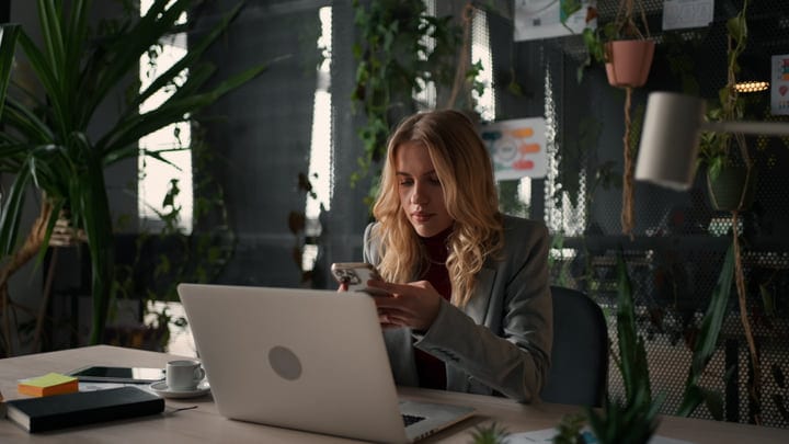 Focused Businesswoman Navigates Her Day In A Lush Office