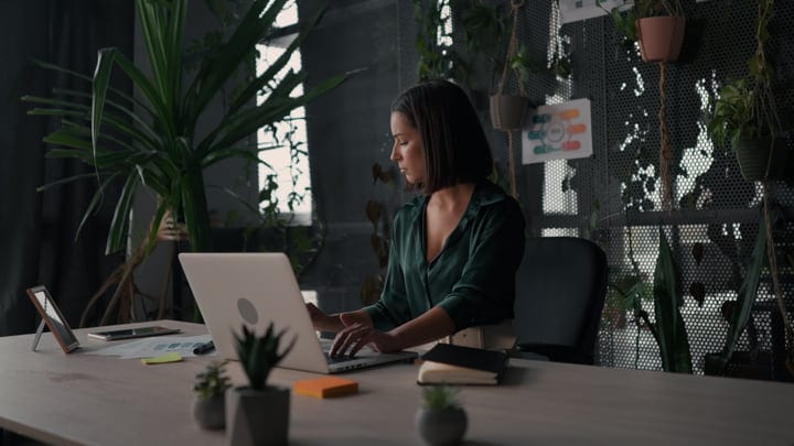 Focused Businesswoman Typing in a Green Office Sanctuary
