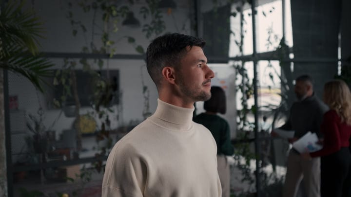 Thoughtful Businessman Observes in a Modern Office Setting