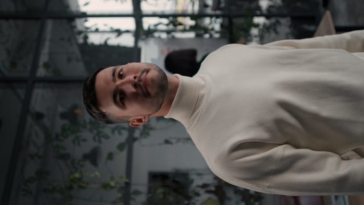 Businessman in Thoughtful Moment Amid Office Greenery