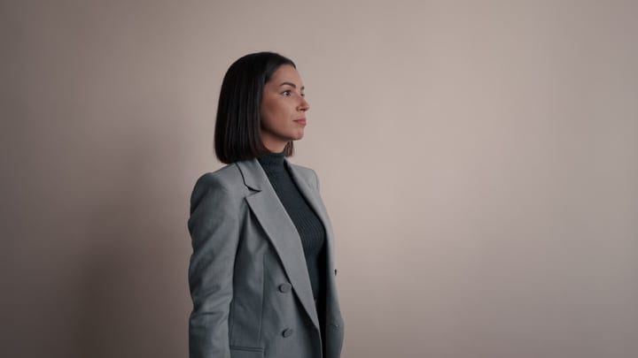 Poised Professional Gazes Ahead In Subtle Office Light