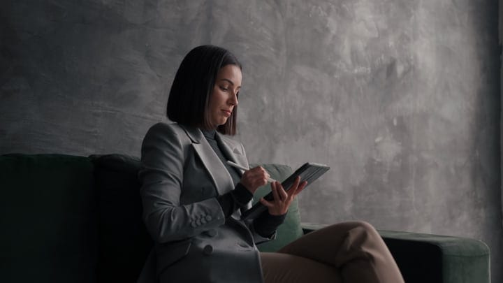 Focused Businesswoman Engages with Digital Tablet in Office Setting