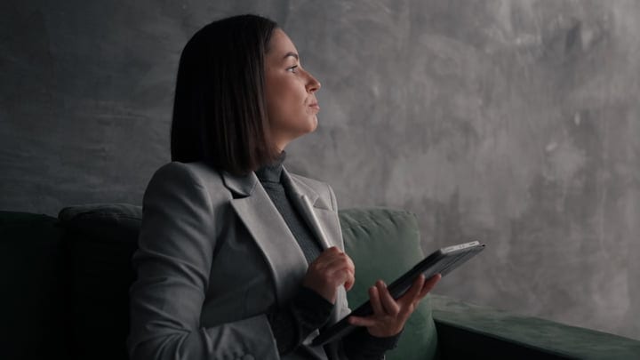 Contemplative Moment For A Businesswoman With Tablet