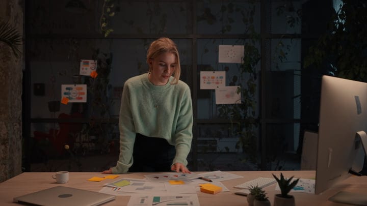 Focused Businesswoman Analyzing Charts Under Soft Office Light