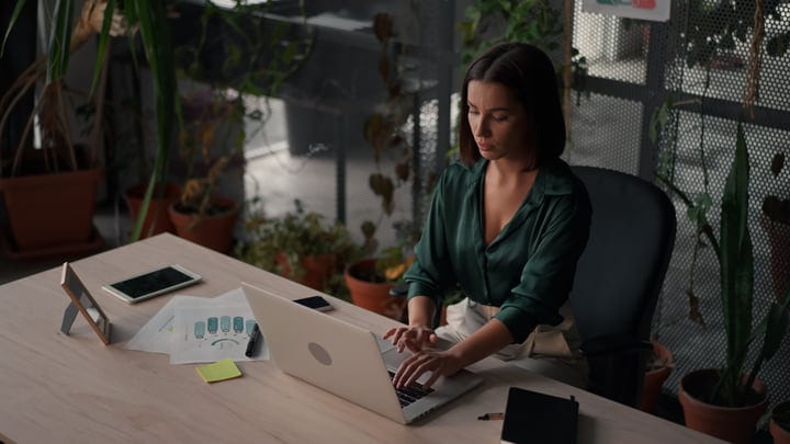 Focused Businesswoman Typing in a Green Office Oasis