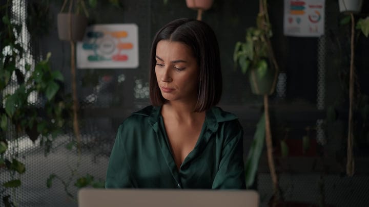 Focused Businesswoman in Modern Office Setting with Greenery
