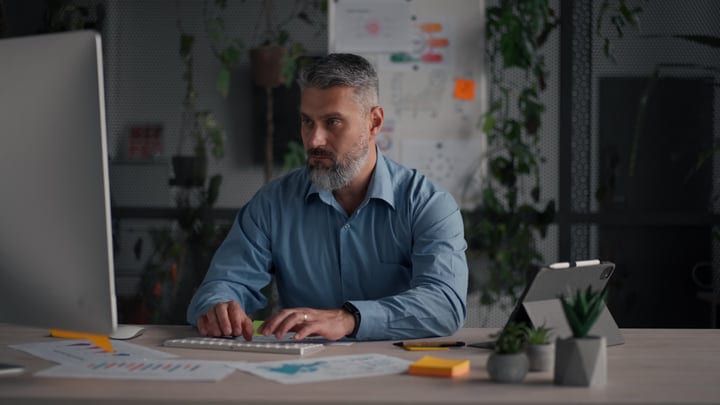 Bearded Man Focused On Computer Work In Modern Office