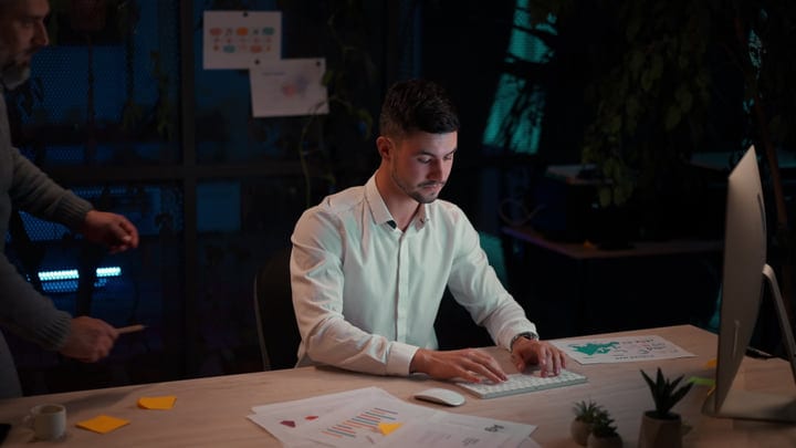 Focused Professional Typing in Dimly Lit Office