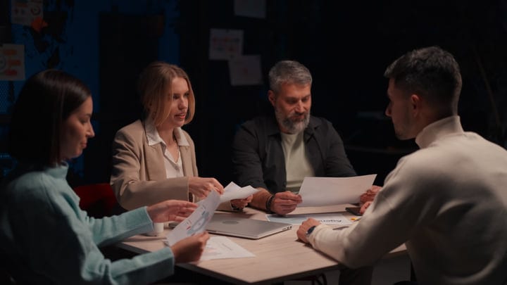 Team Collaborates Over Documents In Modern Office Setting