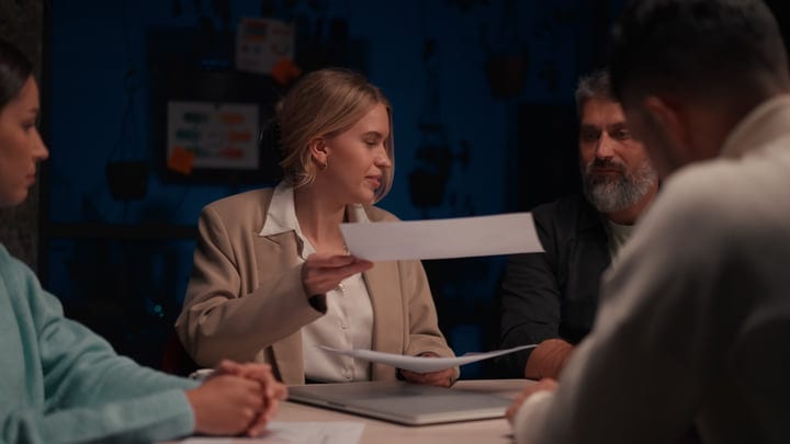 Businesswoman Leads Strategic Meeting In Dimly Lit Office