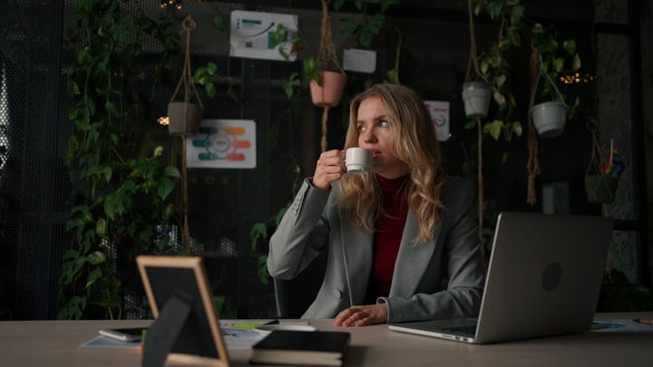 Thoughtful Moment Over Coffee In A Green Office