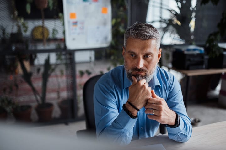 Thoughtful Executive Ponders Strategy In Modern Office Setting
