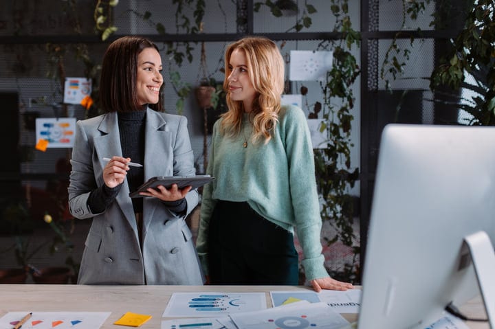 Two Colleagues Share Insights In A Modern Office Setting