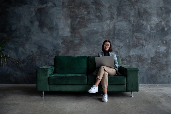 Confident Businesswoman Relaxing With Laptop in Modern Office