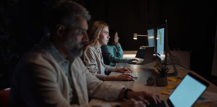 Focused Team Collaborating in a Dimly Lit Office