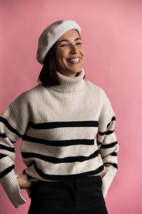 Businesswoman Smiling in Chic Striped Sweater and Beret