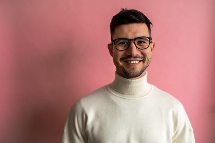 Confident Professional in Turtleneck Against Pink Backdrop