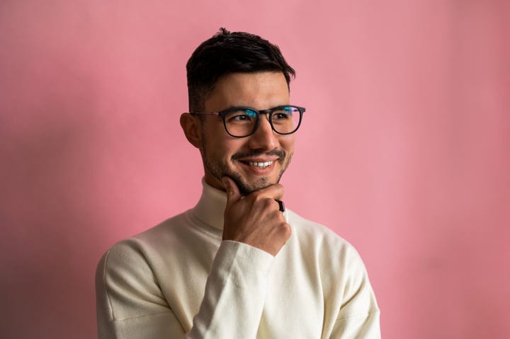 Smiling European Man In Glasses And Turtleneck Posing In Studio