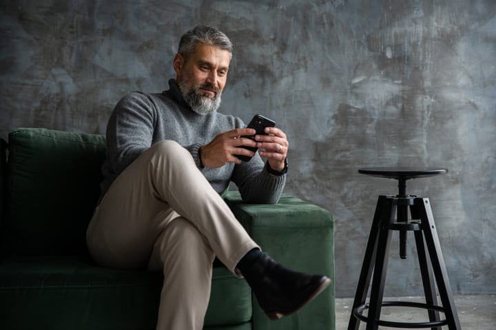 Refined Gentleman Engages with Smartphone in Stylish Setting