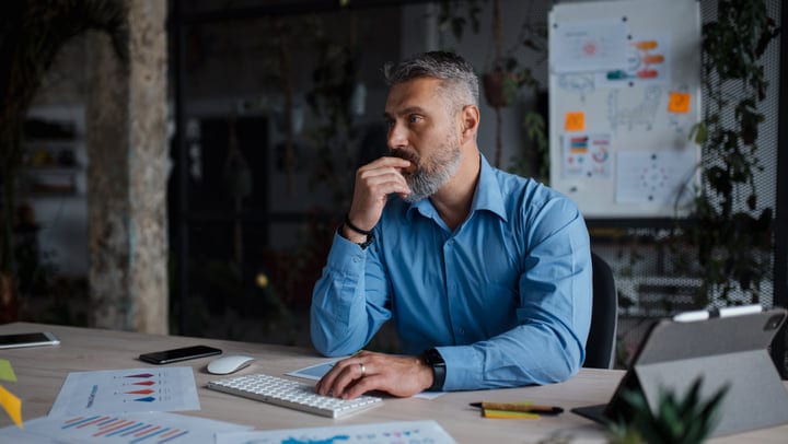Thoughtful Businessman Reflects Over Data In Modern Office