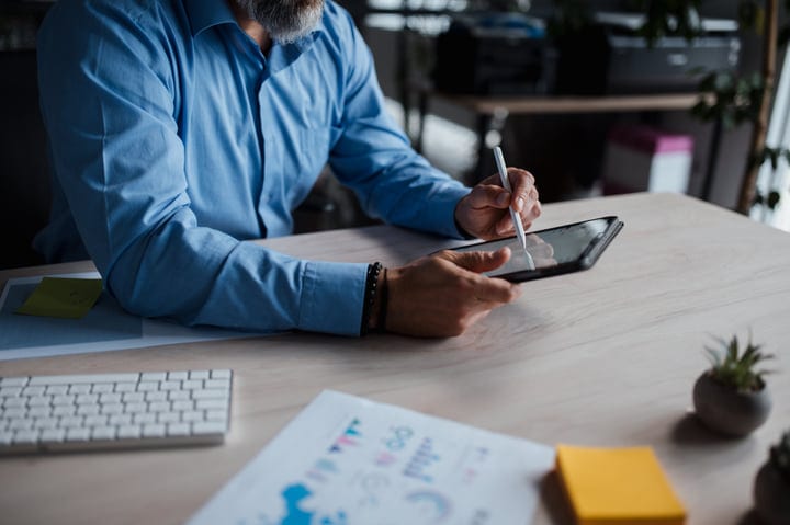 Focused Businesswoman Using Stylus On A Digital Tablet