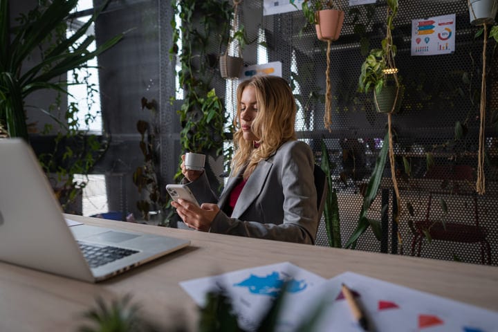 Modern Businesswoman Balances Technology And Coffee In Office
