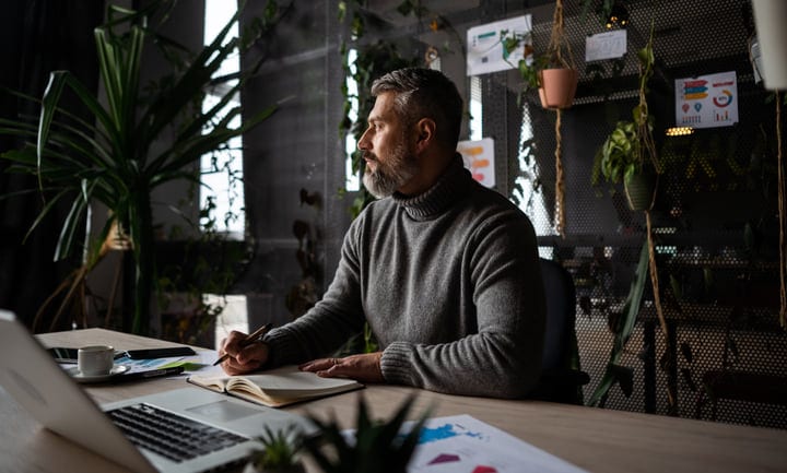 Thoughtful Businessman Reflecting in a Modern Green Office