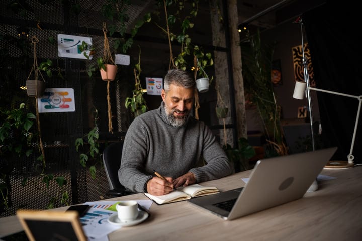 Senior Businessman Embraces Creativity In Green Office Space