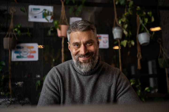 Confident Businessman Smiling in Creative Office Environment