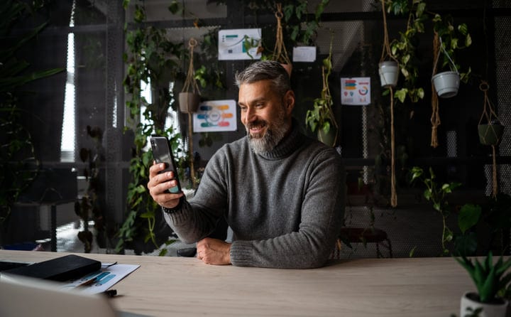 A Businessman Enjoys A Video Call In A Green Office