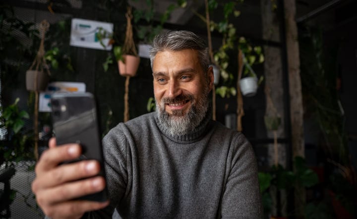 Confident Businessman Enjoys Video Call In Green Office