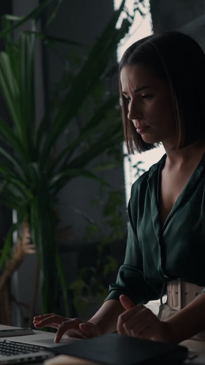 Focused Businesswoman Engages in Thoughtful Office Work
