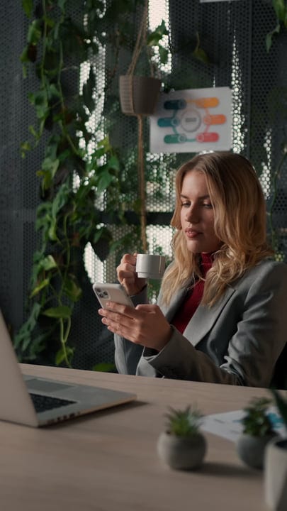 Businesswoman Enjoying a Coffee Break Amidst Office Greenery