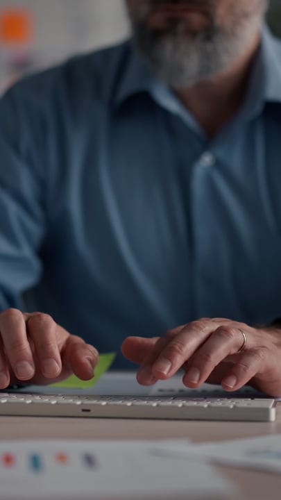Focused Hands Typing On A Keyboard In A Modern Office