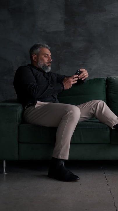 Businessman Relaxing On Green Sofa With Tablet In Hand