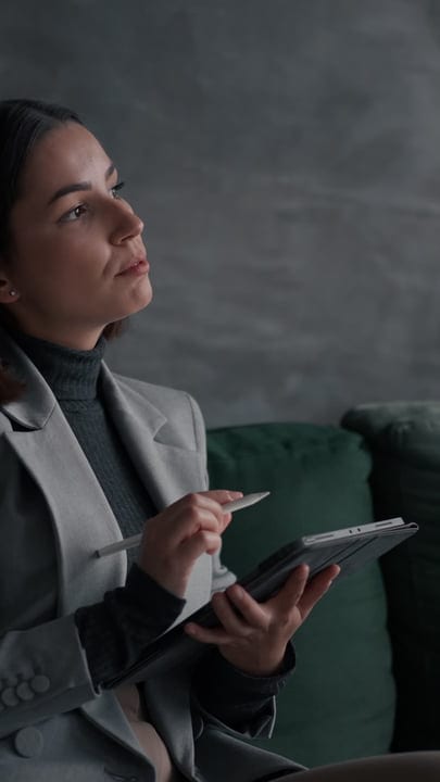 Focused Businesswoman Engages in Thoughtful Tablet Work