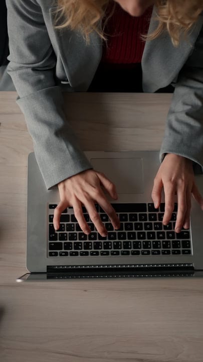 Focused Businesswoman Typing Diligently On Her Laptop