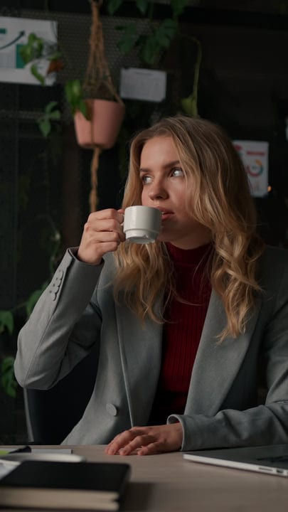 Businesswoman Sipping Coffee During a Busy Office Day