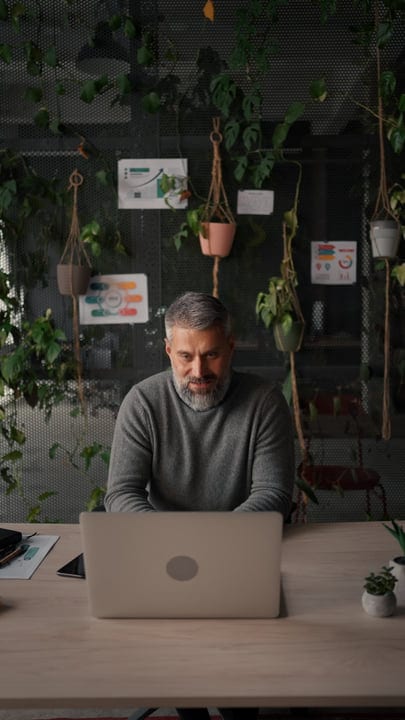 Man Engages in Work Amidst Lush Office Greenery