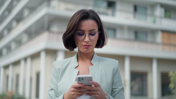 Businesswoman Engages With Smartphone In Vibrant Vienna Setting