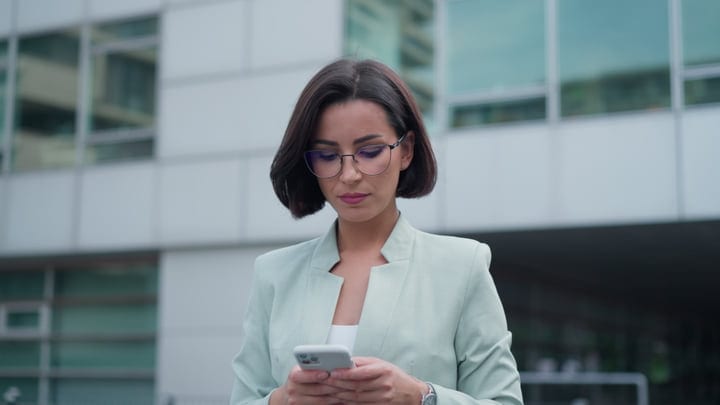 Focused Businesswoman Checks Her Phone In Urban Vienna