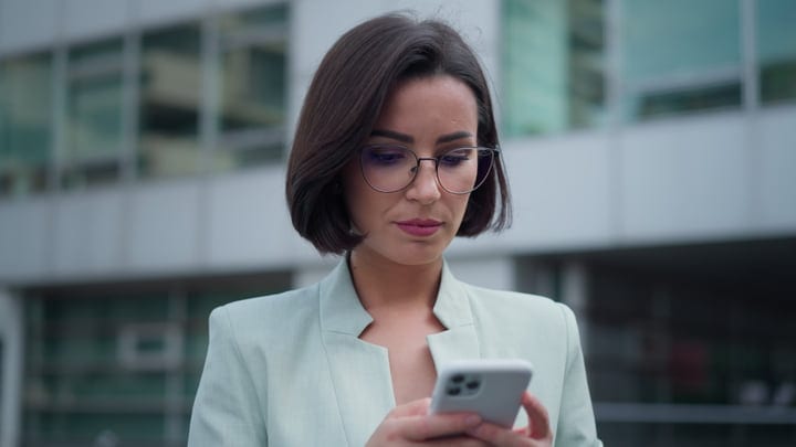 Focused Businesswoman Engages With Her Smartphone in Vienna