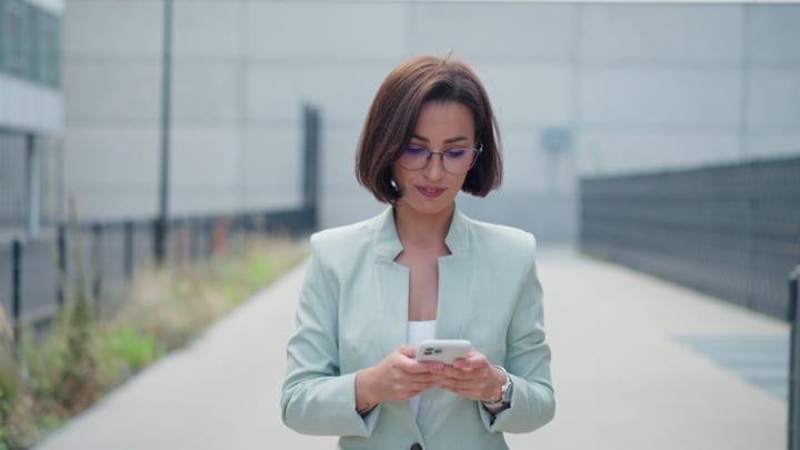 Confident Businesswoman Engages With Her Smartphone In Vienna