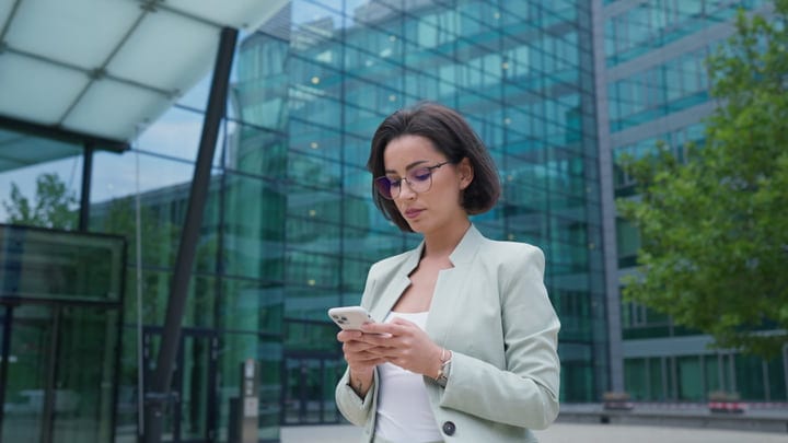 Businesswoman Engages With Her Smartphone In Vienna's Urban Landscape