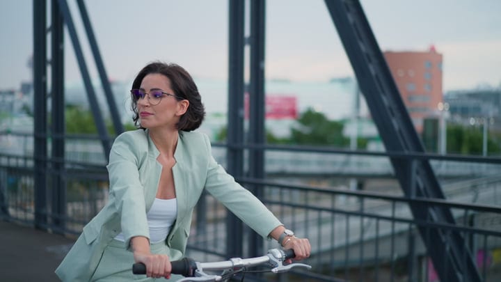 Confident Businesswoman Pedals Through Vienna's Urban Landscape