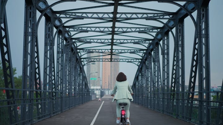 Cycling Through Vienna's Iron Bridge on a Breezy Day