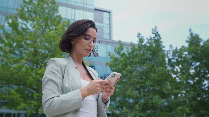 Confident Businesswoman Engages with Smartphone in Vienna's Outdoors