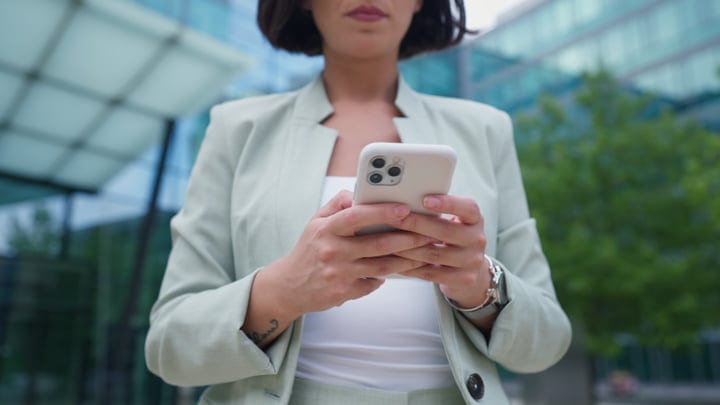 Focused Businesswoman Engages with Smartphone in Vienna's Streets