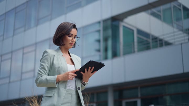 Focused Businesswoman Engages with Tablet Against Vienna Skyline